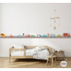 Cenefa infantil amb cotxes de colors a la paret d’una habitació infantil