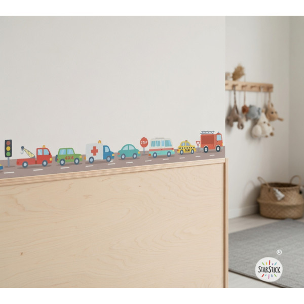 Cenefa infantil amb cotxes de colors a la paret d’una habitació infantil