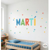 Sticker mural enfant personnalisé avec prénom et triangles colorés sur le mur d’une chambre d’enfant