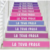 Vinils decoratius a les escales d’un col·legi amb frases motivadores en color lila.