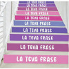 Vinils decoratius a les escales d’un col·legi amb frases motivadores en color lila.